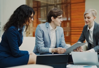 Three professionals discussing documents at a table.